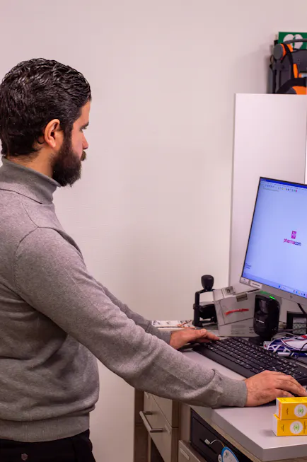 Man werkt aan computer met apparatuur in de buurt.