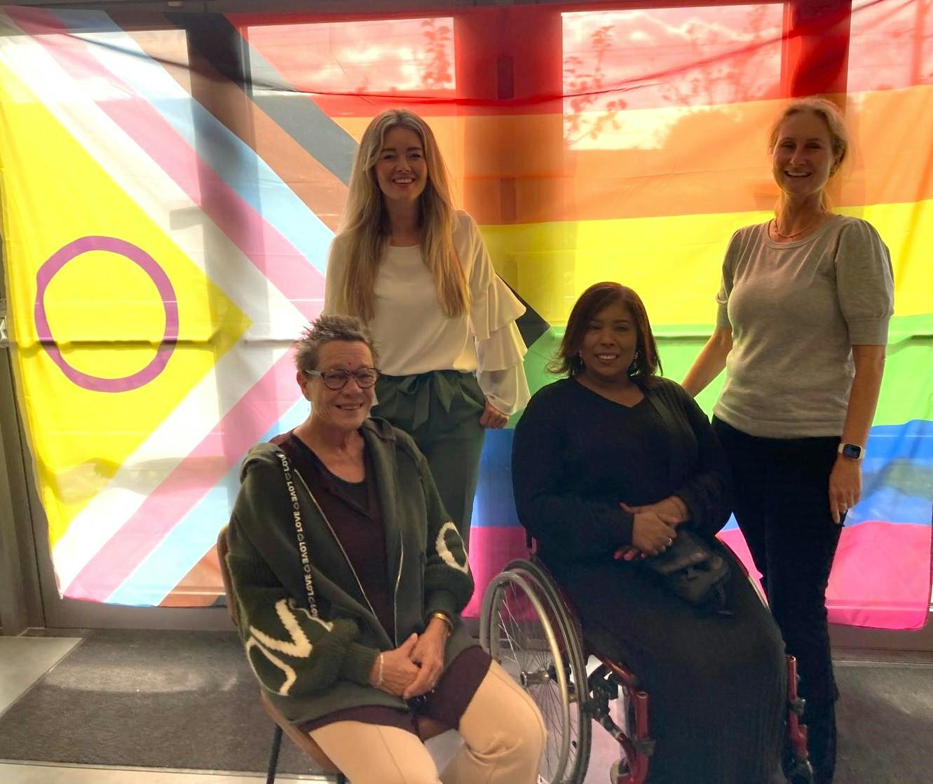 Collega's van projectgroep ongelijkheid verminderen op de foto met progressievlag