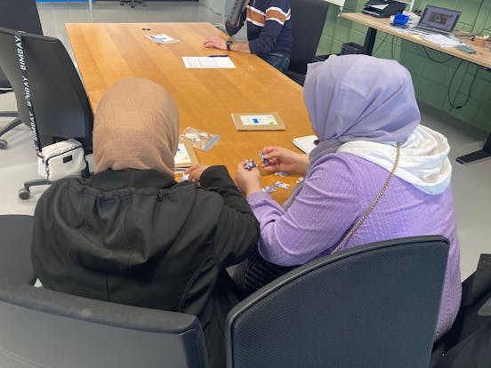 2 vrouwen zittem aan tafel en maken puzzle