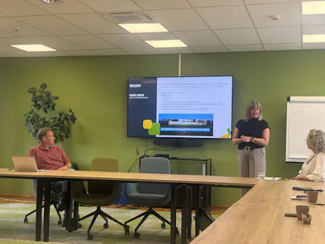 Presentatie in een vergaderruimte met deelnemers.