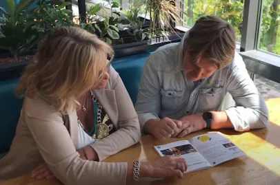 Twee mensen bekijken samen een brochure.