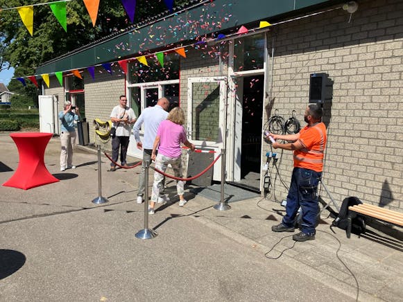 Opening van een gebouw met confetti en slingers.