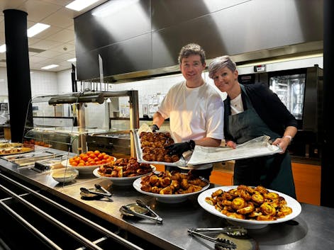 Twee mensen met gebak in een keuken.