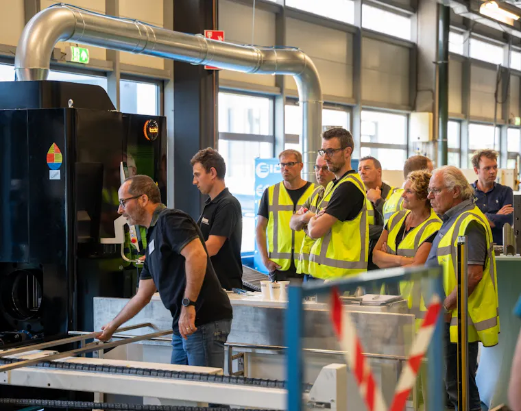 mensen staan bij de nieuwe buizenlaser