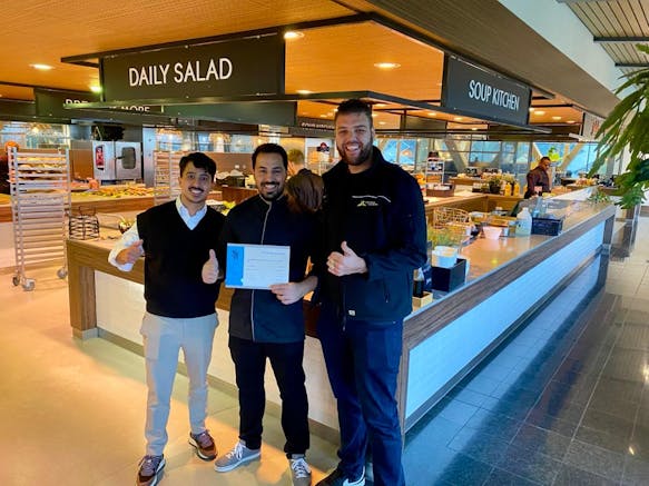 3 mannen naast elkaar en 1 ontvangt diploma