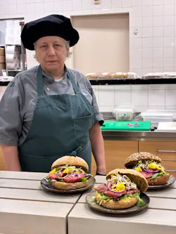 Medewerker presenteert drie belegde broodjes.