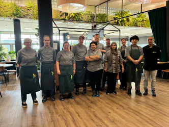 Restaurantteam poseert gezamenlijk in de eetzaal.