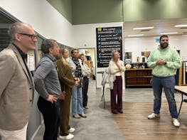 Groep mensen luistert naar een spreker in een zaal.