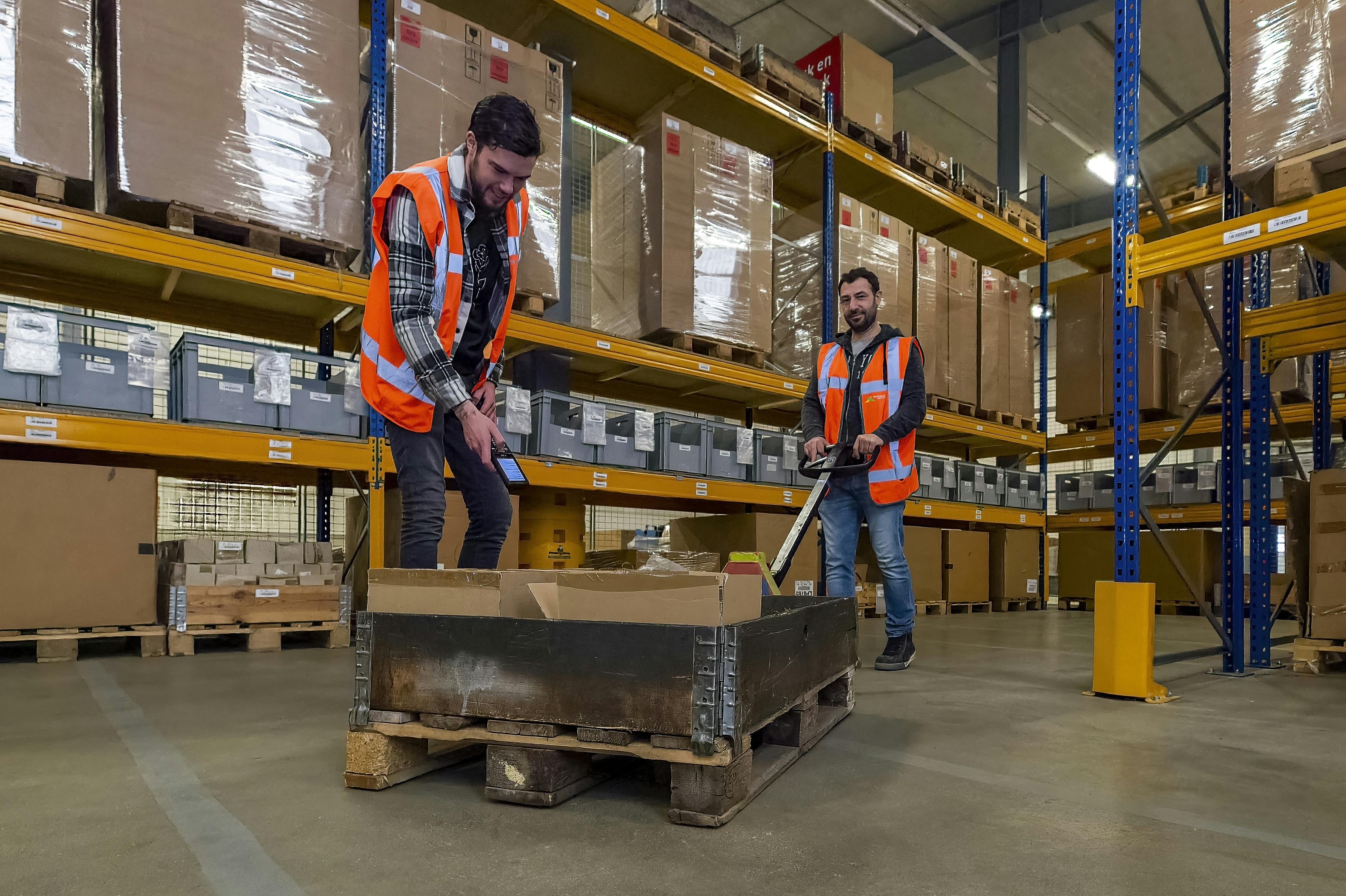 Twee mannen scannen goederen bij logistiek
