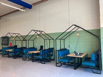 Blauwe werkplekken met verlichting in een ruimte.