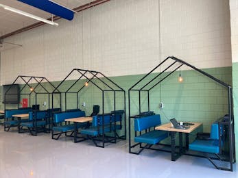 Werkplekken in huisvormige booths, groen- en witgekleurd.