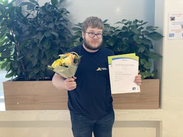 jongen met bloemen en diploma schoonmaak in hand