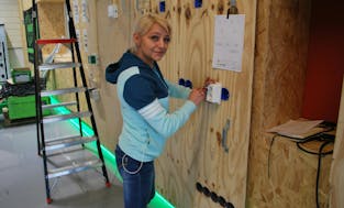 Vrouw aan het werken aan een elektrisch paneel.