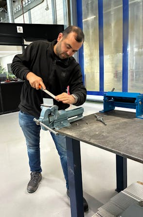 Man werkt met een werkbank en een bankschroef.