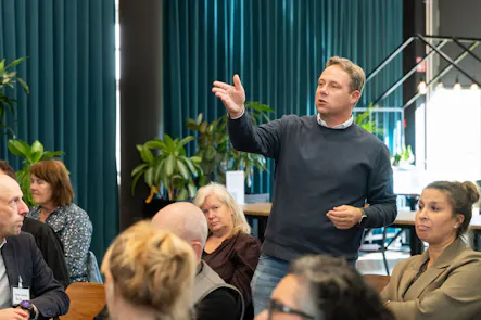 Man spreekt tijdens een bijeenkomst in een kantoor.