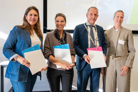 Vier mensen tonen certificaten tijdens een uitreiking