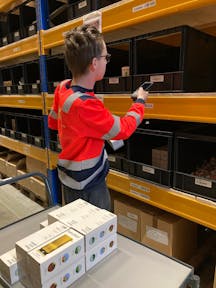 Werknemer scant producten in een magazijn.