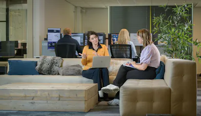 Vrouwen in gesprek op een bank in kantoor.