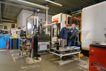 Werknemers in een werkplaats met machines.