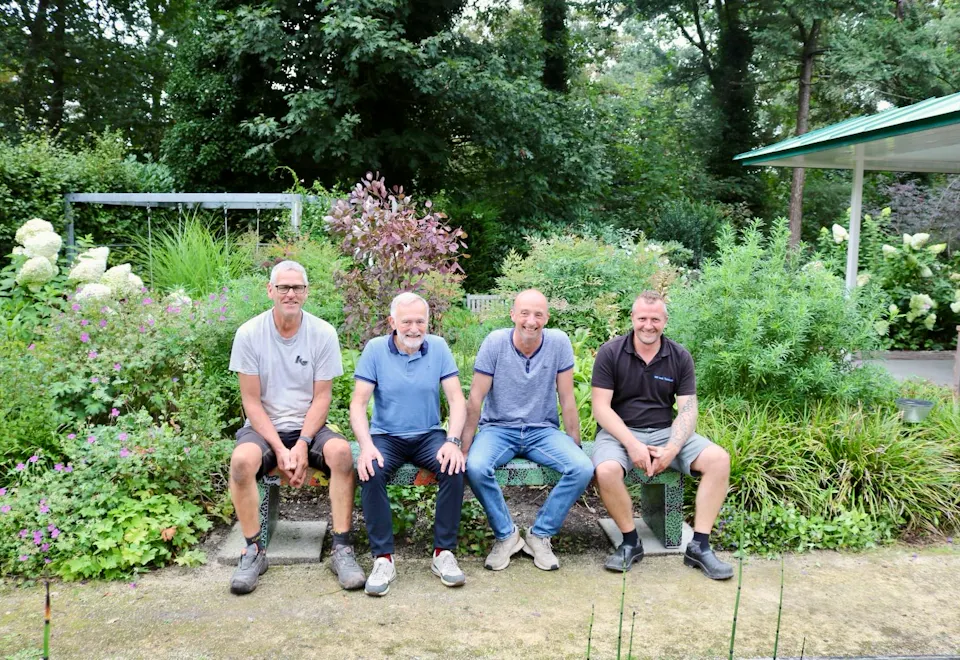 familie-en-vrienden-op-het-mozaiekbankje-in-de-bosrijke-tuin