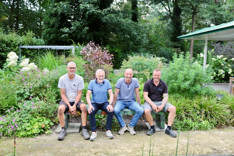 familie-en-vrienden-op-het-mozaiekbankje-in-de-bosrijke-tuin