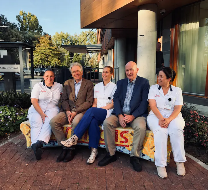 Medewerkers en betrokkenen tijdens de onthulling van de mozaïekbank bij Franciscus Vlietland in Schiedam